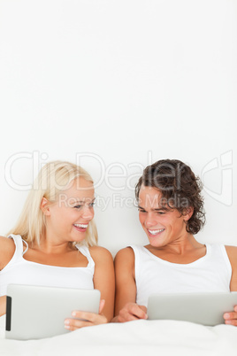 Portrait of a couple smiling using tablet computers