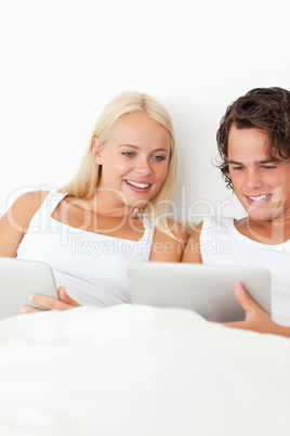 Portrait of a smiling couple using tablet computers