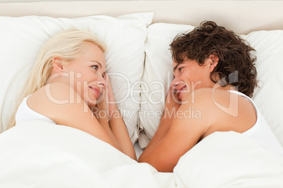 Portrait of a smiling couple lying while looking at each other