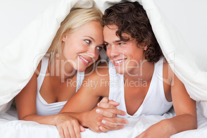 Portrait of an in love couple under a duvet