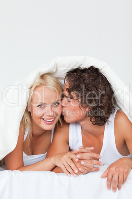 Portrait of a man kissing his girlfriend on the cheek