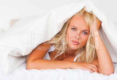 Blonde woman under a duvet