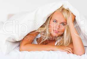 Blonde woman under a duvet