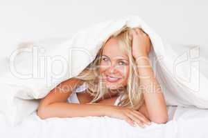 Smiling woman under a duvet