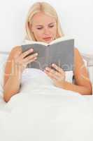 Portrait of a blonde woman reading a book