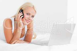 Blonde woman on the phone with a laptop