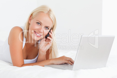 Blonde woman on the phone with a notebook