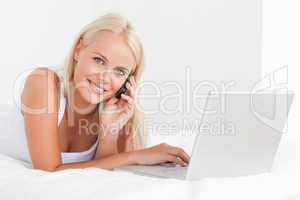 Blonde woman on the phone with a notebook