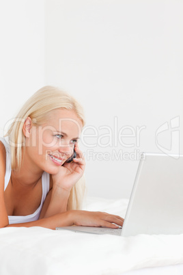 Portrait of a woman on the phone using a notebook