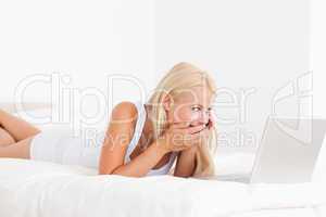 Woman laughing on the phone while using a laptop