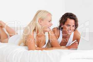 Laughing couple using a notebook