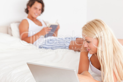 Woman with a notebook while her fiance is with a book