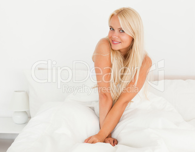 Woman sitting on her bed