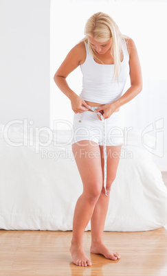 Blonde woman measuring her belly