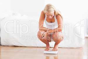 Fit woman on a weighing machine