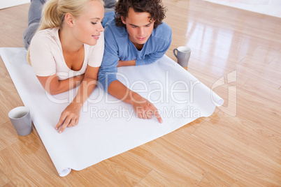 Young couple looking at their future room on a plan