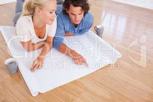 Young couple looking at their future room on a plan