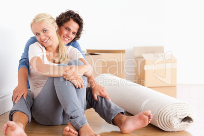 Happy couple sitting on the floor
