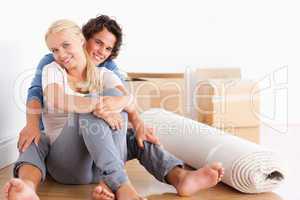 Happy couple sitting on the floor