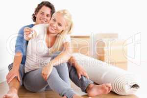 Woman sitting with her fiance giving keys