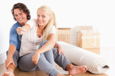 Woman sitting with her boyfriend giving keys