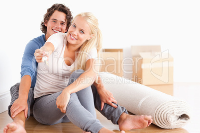 Cute woman sitting with her boyfriend giving keys