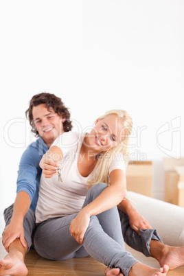 Portrait of a woman sitting with her boyfriend giving keys