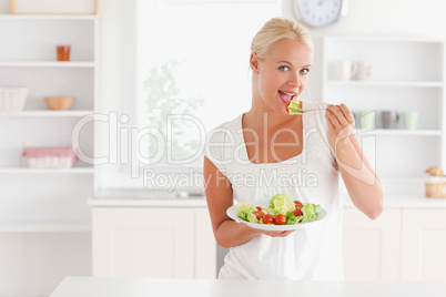 Blonde woman eating a salad