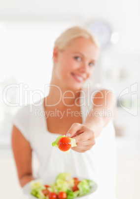 Portrait of a woman giving a tomato