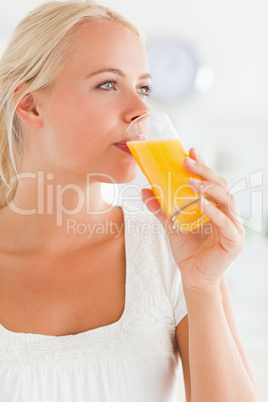 Portrait of a blonde woman drinking juice