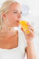 Portrait of a blonde woman drinking juice