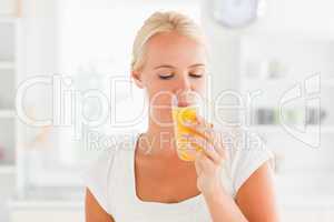 Blonde woman drinking orange juice