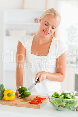 Blonde woman slicing pepper