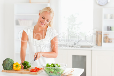 Beautiful woman slicing pepper