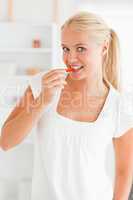 Portrait of a woman eating a slice of pepper