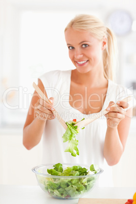 Portrait of a woman mixing a salad