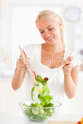 Portrait of a smiling woman mixing a salad