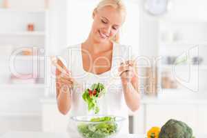 Smiling woman mixing a salad