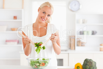 Cute woman mixing a salad