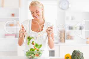 Gorgeous woman mixing a salad