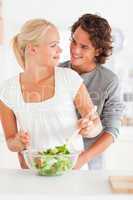 Portrait of a smiling couple preparing a salad