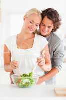 Portrait of a couple preparing a salad