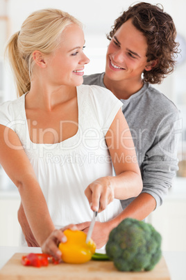 Portrait of a smiling couple slicing pepper