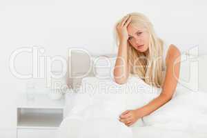 Sick woman sitting on her bed