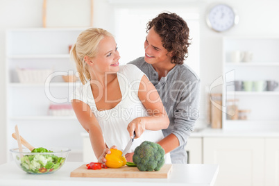 Happy couple slicing pepper