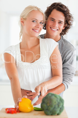 Portrait of a lovely couple slicing pepper