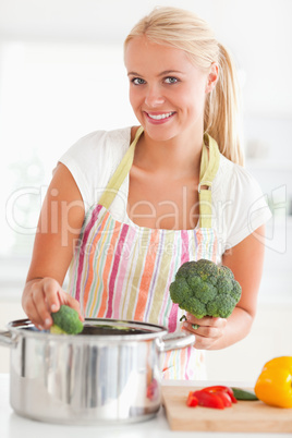 Portrait of a smiling woman putting cabbage on water