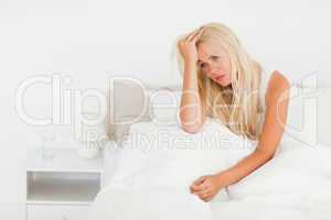 Ill woman sitting on her bed