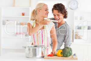 Woman making her fiance tasting her meal