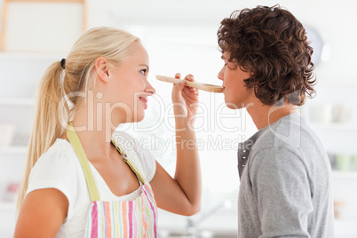 Blonde woman making her fiance tasting her meal